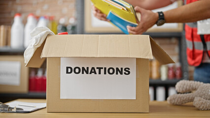 Grey-haired man volunteer packing books to donate at charity center