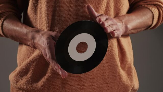 Retro Vinyl records in man hands close-up macro. Old disck for music. Retro vintage music player at home