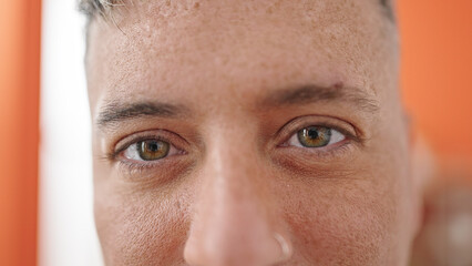 Young caucasian man close up of eyes smiling at home