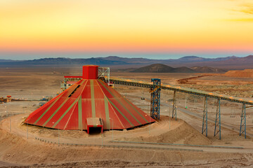 Conveyor belt and stockpile under a dome at an open-pit copper mine in Chile.