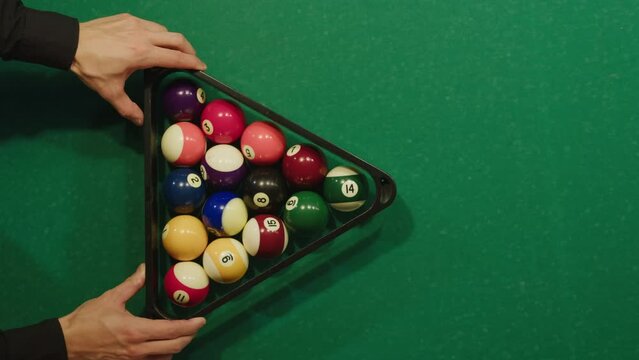 Beginning of game colorful pool balls top view on green billiards table for start to play. American pool, poule. Billiard balls with numbers on a pool table. Billiards team sport.