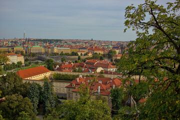 Obraz premium Panoramic view of the city of Prague from the observation deck. Streets and architecture of the old city. Romantic town panorama, historical buildings, red roofs, churches.