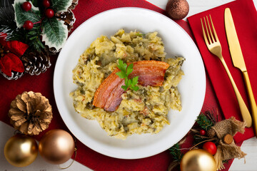Trinxat de la Cerdaña. Typical recipe from the north of Catalonia cooked with white cabbage, potato and bacon. Christmas food served on a table decorated with Christmas motifs.