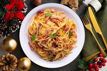 Spaghetti Carbonara. Christmas food served on a table decorated with Christmas motifs.