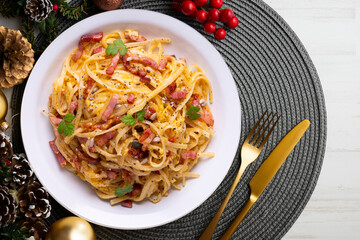 Spaghetti Carbonara. Christmas food served on a table decorated with Christmas motifs.