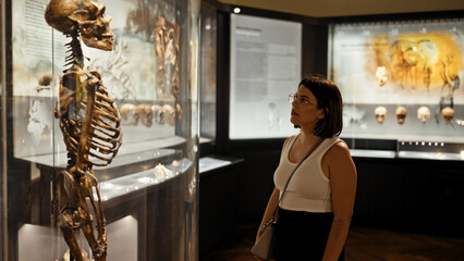 Young beautiful hispanic woman visiting anthropological exhibition at Natural History Museum in...