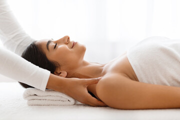 Obraz na płótnie Canvas Joyful woman getting relaxing body shoulders massage at wellness center