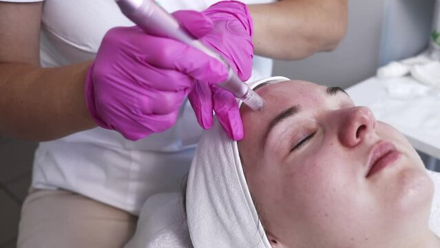Cosmetologist Making Mesotherapy Injection With Dermapen On Face, Cheek Area Of Young Woman For Rejuvenation In Spa Center. Patient Getting Needle Mesotherapy, Skincare. Horizontal Slow Motion