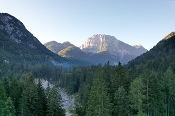 Obraz premium Lago del Predil near Tarvisio aerial panorama view, Italy, featuring turquoise alpine lake surrounded by forested mountains ner Dolomites 