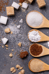 Various types of sugar in bamboo spoons, wholemeal, white and liquorice flavoured - obrazy, fototapety, plakaty