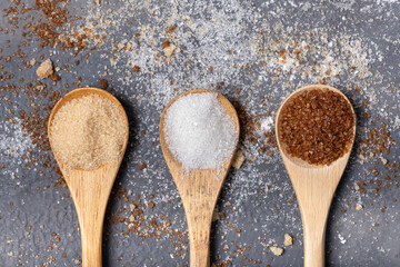 Various types of sugar in bamboo spoons, wholemeal, white and liquorice flavoured - 685823903