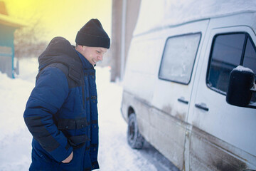 truck driver in winter in winter clothes with a car.