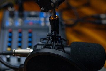 Podcasting studio copy space background image, close up of microphone and sound board, selective focus background image.