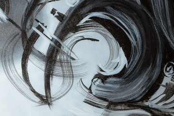 Dark brush strokes on a textured canvas. Black and white abstract background. A fragment of an abstract painting created in an art studio. A stroke of oil paint on linen.