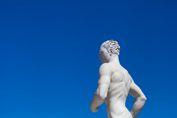 Athlete Marble statue portrait against blue sky.