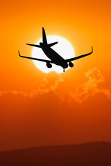 Silhouette of a passenger flight story with tourists landing at the airport. Airplane landing at sunset. passenger plane is landing in the airport runway at early morning at sunrise time