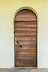 A wooden arched door on the outside of the building