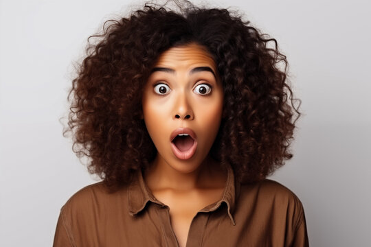A black woman expressing surprise and shock emotion with her mouth open and big wide open eyes. white background
