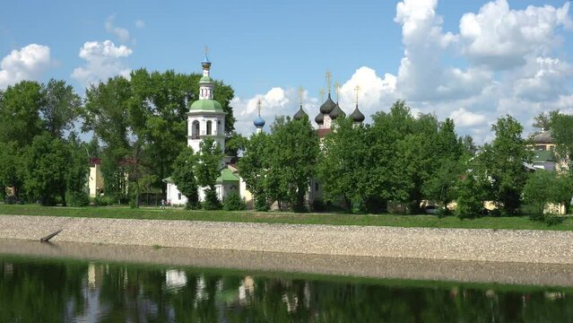 iew of the river embankment with historic churches and wooden houses in Vologda on a sunny summer day