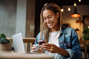 Woman smiling and using mobile for online payment in a coffee shop - obrazy, fototapety, plakaty