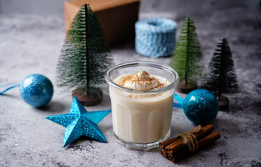 Eggnog with cinnamon decorated with whipped cream in a glass