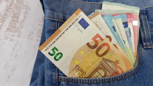 plusieurs billets de banque dans la poche d'un jeans, en gros plan