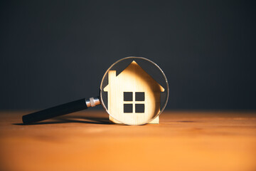Wooden house and magnifying glass