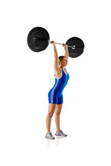 Competition. Full-length of young woman in sportswear, lifting heavy barbell against white background. Concept of sport, strength, gym, healthy lifestyle, power and endurance, weightlifting.