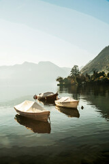 Awe view on lake Como at winter with boats anchored next to shore and coastline with trees and...