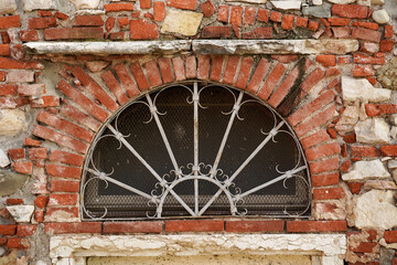 The pattern of an ancient Italian wall with an old window.