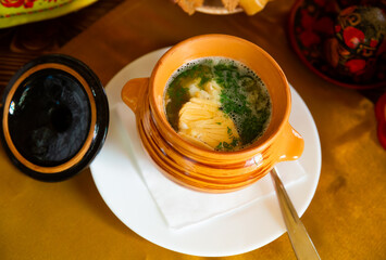 Image of a delicious fish soup with herbs in a pot.