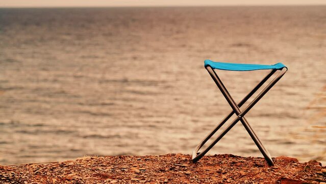 Empty folding camp chair on beach nature. Holidays relaxation on trip. Vacation in the camping. Freedom and travel concept.