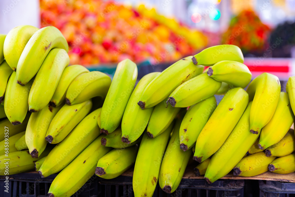 Wall mural bunch of sweet bananas lie on counter in grocery store