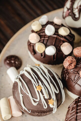 Chocolate bomb with cocoa powder and mini marshmallow to prepare a fragrant hot drink. On dark wooden background.