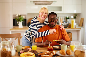 Obraz na płótnie Canvas Multiracial couple having tender moment over breakfast at home