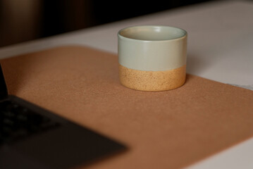 Ceramic Mug With Tea Coffee On The Cork Desk Pad Mat On Top Of The Office Table. A Concept Of Remote Work Advantages