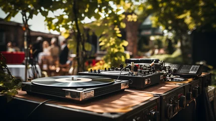Fototapeten DJ table with vinyl records and mixer at outdoor event © Matthias