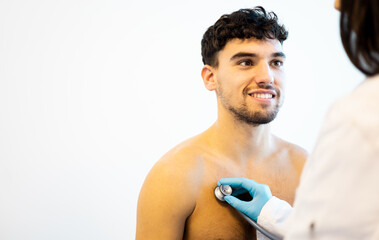 An unrecognizable doctor uses a stethoscope on the chest of a young patient to diagnose...