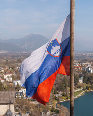 Slovenian flag at beautiful Lake Bled with town in the background