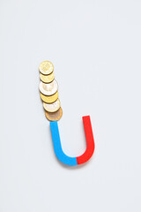 Magnet with coins on white background. Attracting investments concept