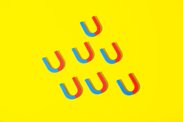 Horseshoe shaped magnets on yellow background