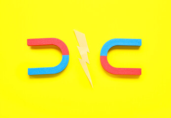 Paper lightning with horseshoe shaped magnets on yellow background