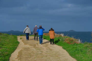 Personnes âgées qui marchent sur le sentier GR34 côte de granit rose-Bretagne France