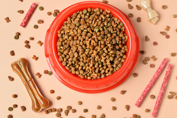 Composition with bowl of dry dog food and different treats on color background