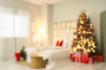 Blurred view of festive bedroom with cozy bed and Christmas tree