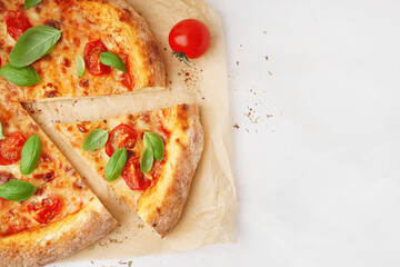 Baking paper with tasty pizza Margarita and basil on white background