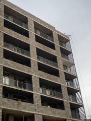 A gloomy gray building. Unfinished brutalist house. Concept of crisis in construction. Gray architecture. Cloudy autumn weather. Concrete house for people.