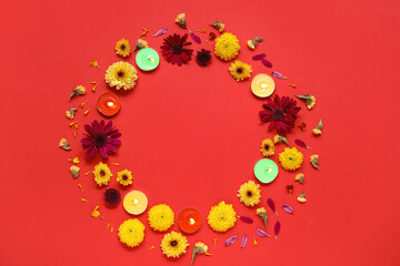 Frame made of burning candles and beautiful flowers on red background. Divaly celebration