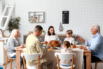 Happy family having dinner at festive table on Thanksgiving Day