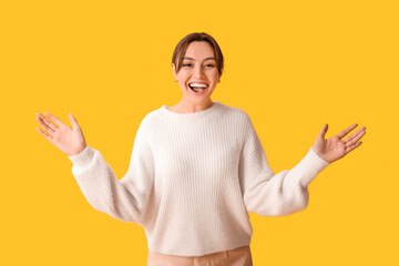 Beautiful woman opening arms for hug on yellow background